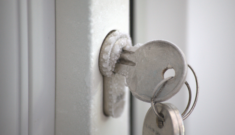 παγωμένος κύλινδρος κλειδαριάς με τα κλειδιά πάνω στην πόρτα